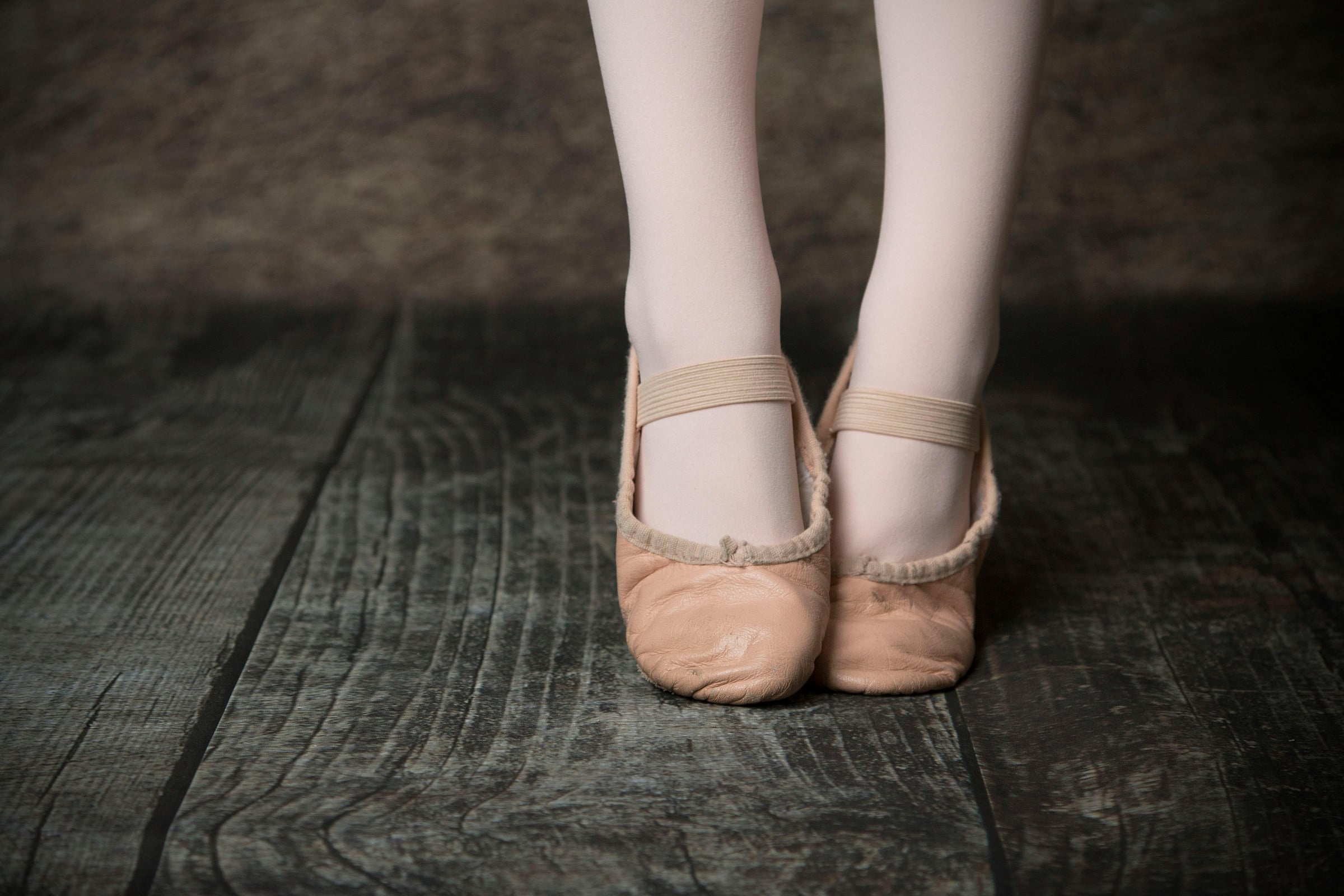 Ballet shoes resting on a wooden studio floor